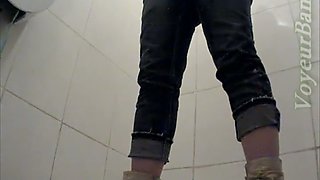 White chick in warm clothes pisses in the toilet room and wipes her pussy