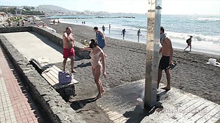 Busty MILF is walking almost naked on the public beach making everyone blush