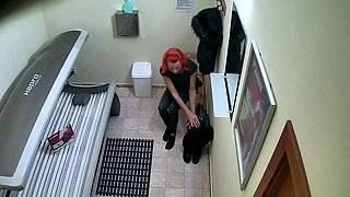 Red MILF rubs her pussy in solarium