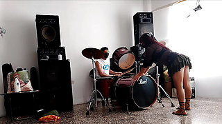They play the drums for her - she dances, stripping and showing her ass