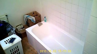 Brunette relaxes in bath and plays with her body