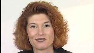Tattooed ginger milf is filling her pussy with a big dildo