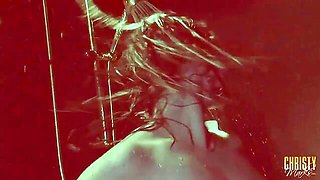 Huge-breasted brunette gets splashed with water under red lights in slow motion